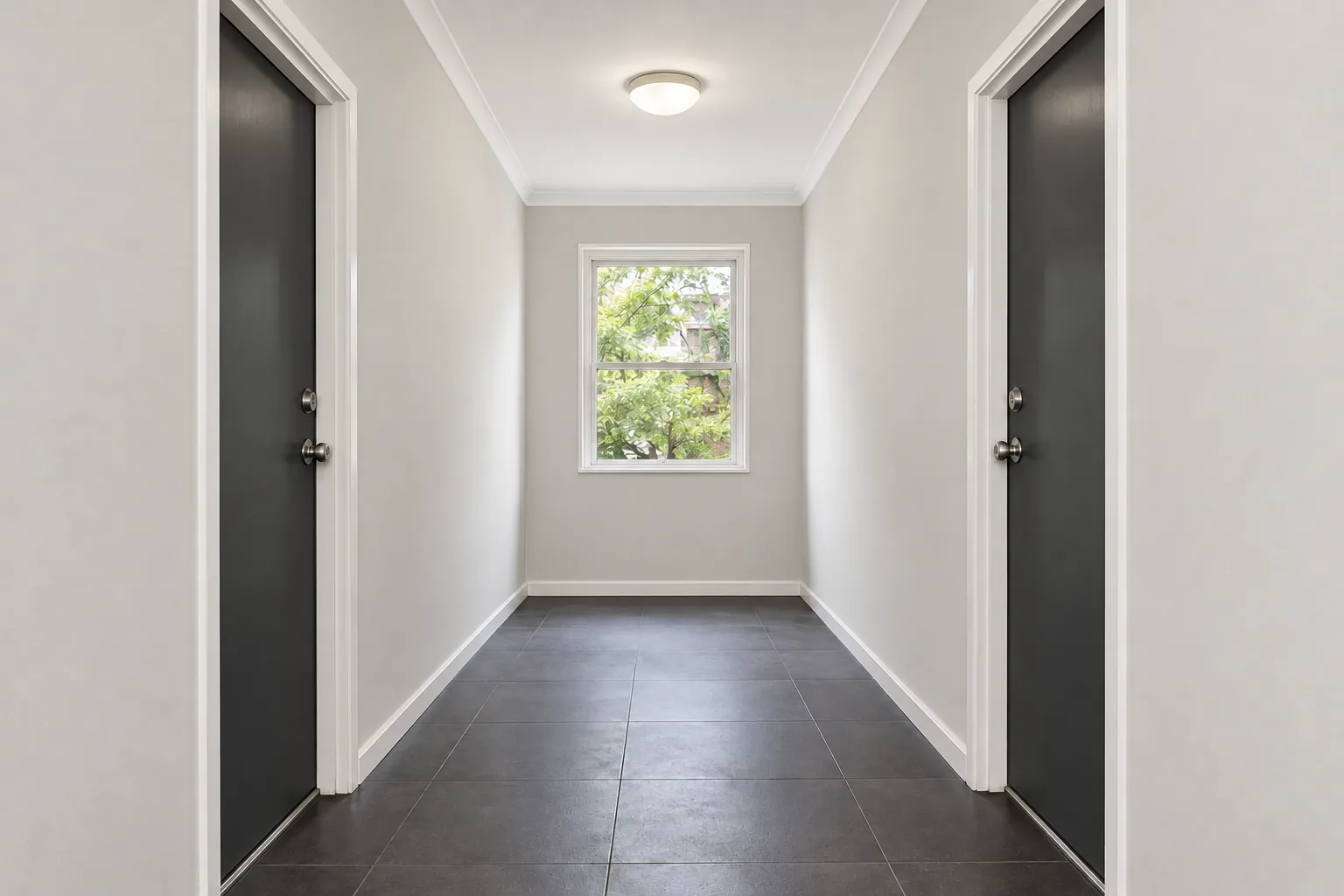 AI-generated hypothetical after view: apartment common hallway with light walls and charcoal doors