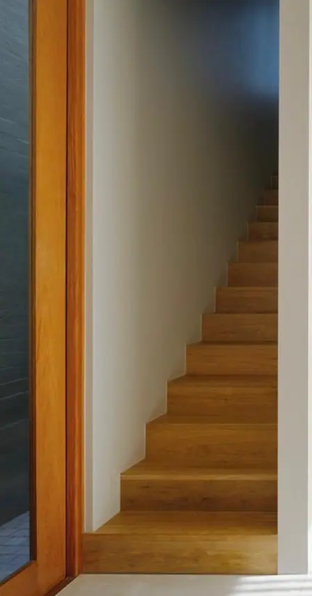 Timber staircase beside a white wall and timber door frame at the Queens Park renovation, painted by Proview Painting