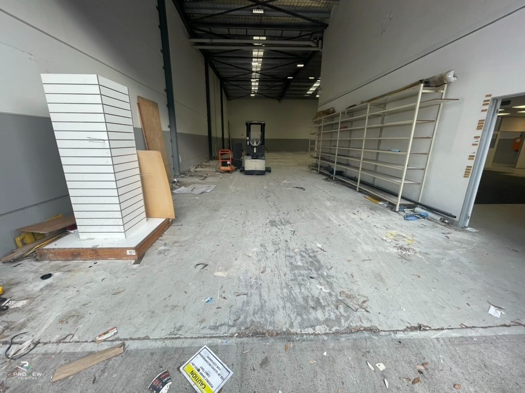 Before — bare concrete aisle with old racking and debris