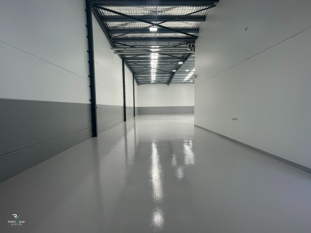 After — the same aisle with fresh walls and glossy epoxy floor